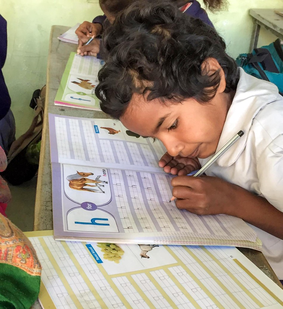 Một em học sinh đang cặm cụi viết chữ cái. Được biết, mỗi năm phải thay sách mới nên chi phí không hề nhỏ cho các em Một em học sinh đang cặm cụi viết chữ cái. Được biết, mỗi năm phải thay sách mới nên chi phí không hề nhỏ cho các em