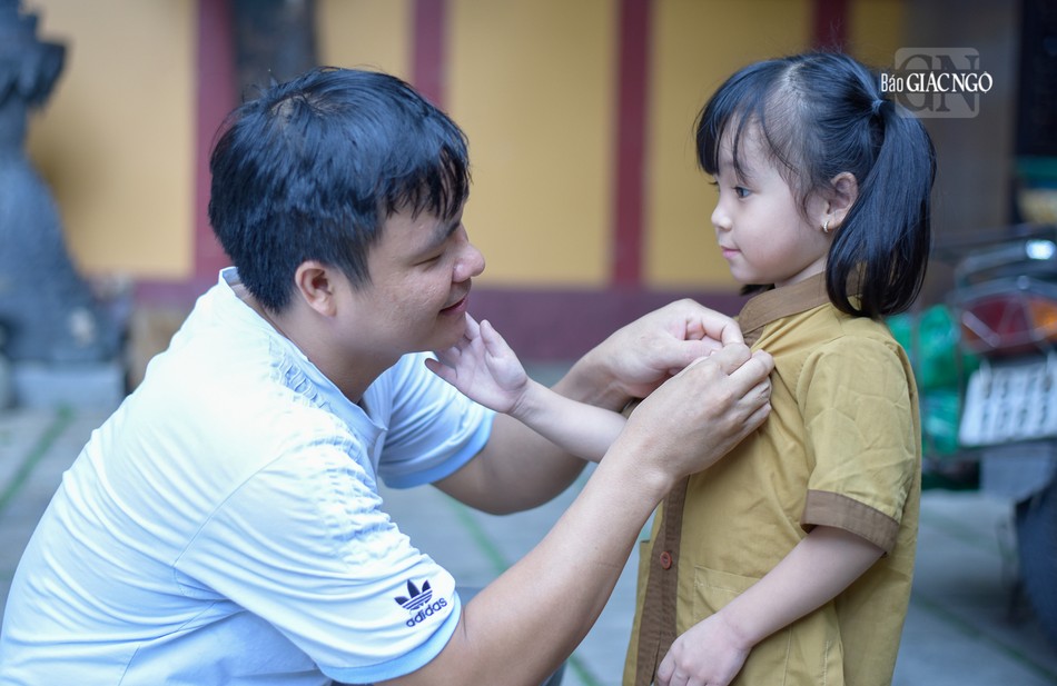 Anh Phạm Đăng Hùng (32 tuổi), ba bé Bông đang chỉnh sửa lại hoa hồng trên ngực của con gái