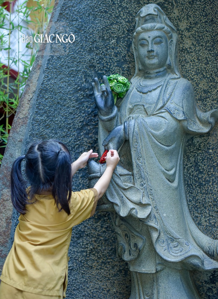 Bắt chước mọi người, em dâng một đóa hoa lên cúng dường Bồ-tát Quán Thế Âm với tâm nguyện cầu mong sự che chở của mẹ hiền