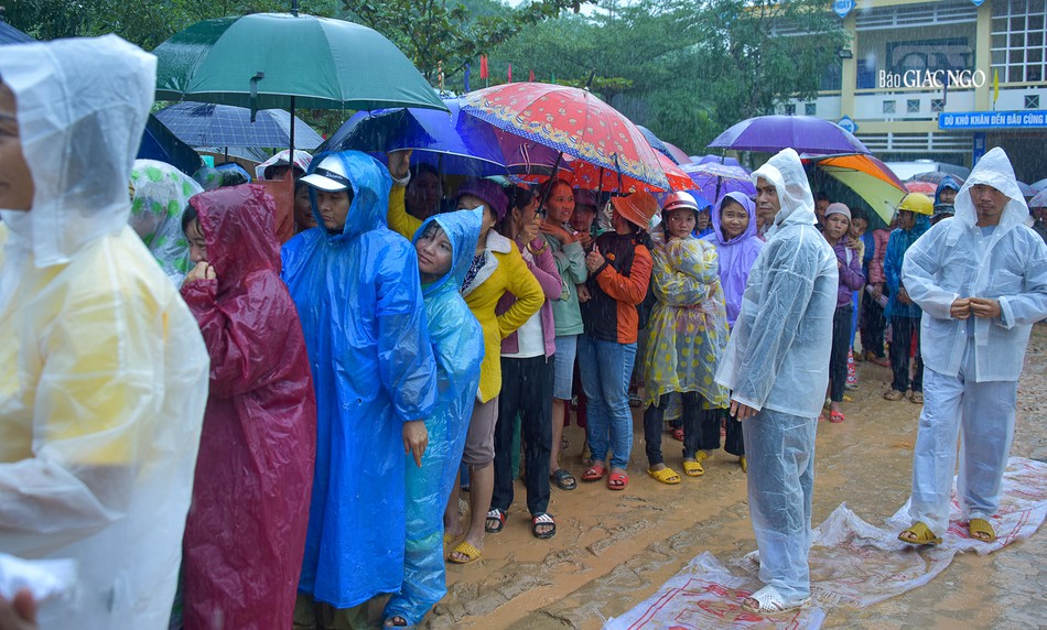 Hình ảnh người dân xếp hàng dưới mưa chờ nhận quà