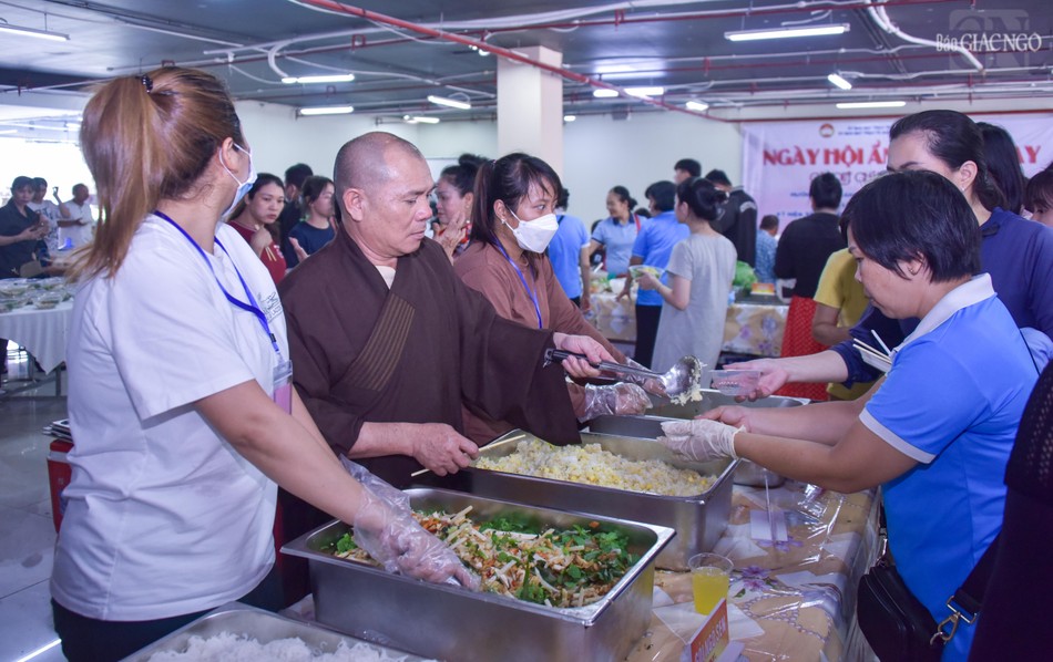 Thượng tọa Thích Tâm Tài, Trưởng ban Từ thiện Xã hội Phật giáo Q.7 cùng các Phật tử chùa Long Hoa phục vụ các món ăn chay đến thực khách