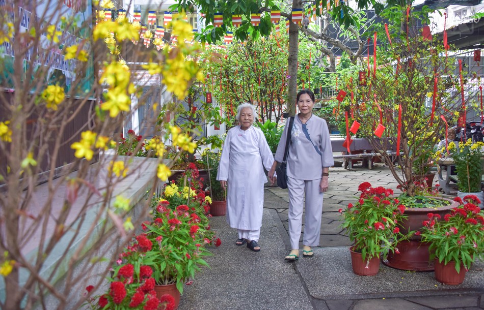 Rằm tháng Giêng, nhiều gia đình về chùa để nghe pháp, tụng kinh. Trong ảnh là 2 mẹ con Phật tử Viên Ngọc (93 tuổi) đến chùa tham dự lễ cúng hội rằm tháng Giêng theo truyền thống của hệ phái Khất sĩ