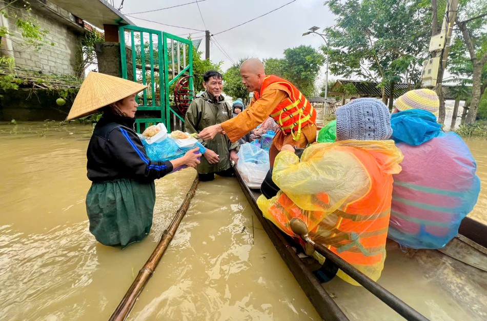 Đại đức Thích Minh Phú trao quà tận tay một người dân bị ngập lũ tại tổ dân phố Giáp Đông, phường Kim Trà, TP.Huế