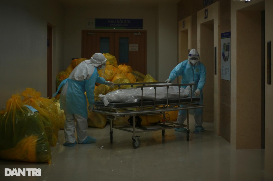 Giữa đêm, không khí bên trong khu hồi sức trở nên trầm xuống, mọi ánh mắt đều hướng về phía chiếc xe đẩy giữa hành lang. Một bệnh nhân 85 tuổi mắc Covid-19 vừa tử vong do bệnh nền nặng. Nhân viên y tế thực hiện quy trình xử lý nghiêm ngặt đối với ca bệnh tử vong rồi chuyển đi làm thủ tục, và báo về cho gia đình. Giữa đêm, không khí bên trong khu hồi sức trở nên trầm xuống, mọi ánh mắt đều hướng về phía chiếc xe đẩy giữa hành lang. Một bệnh nhân 85 tuổi mắc Covid-19 vừa tử vong do bệnh nền nặng. Nhân viên y tế thực hiện quy trình xử lý nghiêm ngặt đối với ca bệnh tử vong rồi chuyển đi làm thủ tục, và báo về cho gia đình.