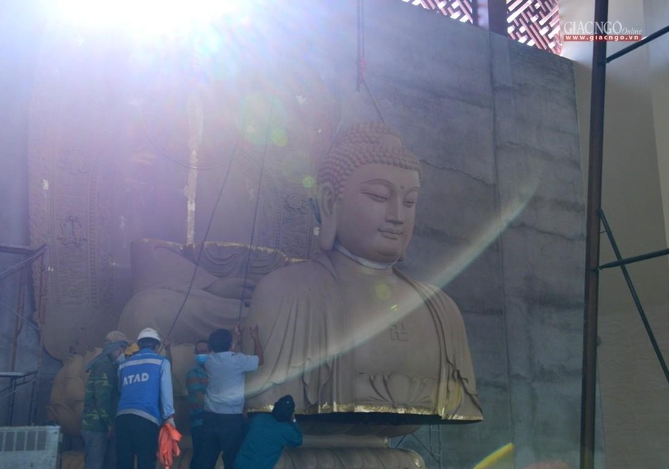 Trong khi các kỹ thuật viên nâng ghép các phần của kim thân được tôn tạo rời Trong khi các kỹ thuật viên nâng ghép các phần của kim thân được tôn tạo rời