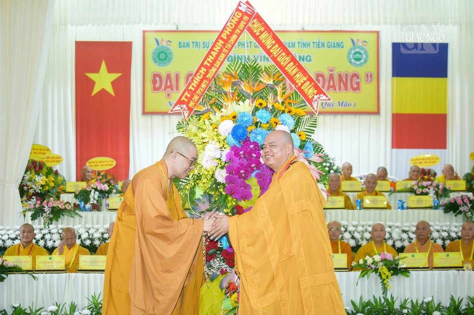 Thượng tọa Thích Quảng Lộc đón nhận lẵng hoa chúc mừng đến từ Thượng tọa Thích Thanh Phong, Phó Chủ tịch Hội đồng Trị sự, Trưởng ban Kinh tế Tài chánh T.Ư