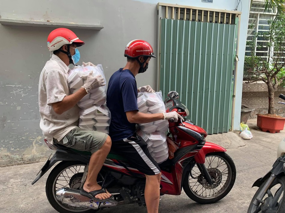 Các tình nguyện viên phân công tặng cơm tại các quận huyện - Ảnh: T.N