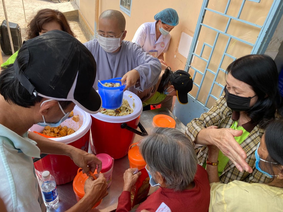 Ni sư Thích nữ Huệ Dâng phân suất cơm đến bệnh nhân nghèo - Ảnh: Lê Nam