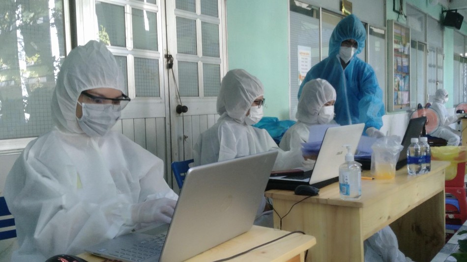 Tình nguyện viên hỗ trợ ghi danh sách người dân tiêm vắc-xin Tình nguyện viên hỗ trợ ghi danh sách người dân tiêm vắc-xin