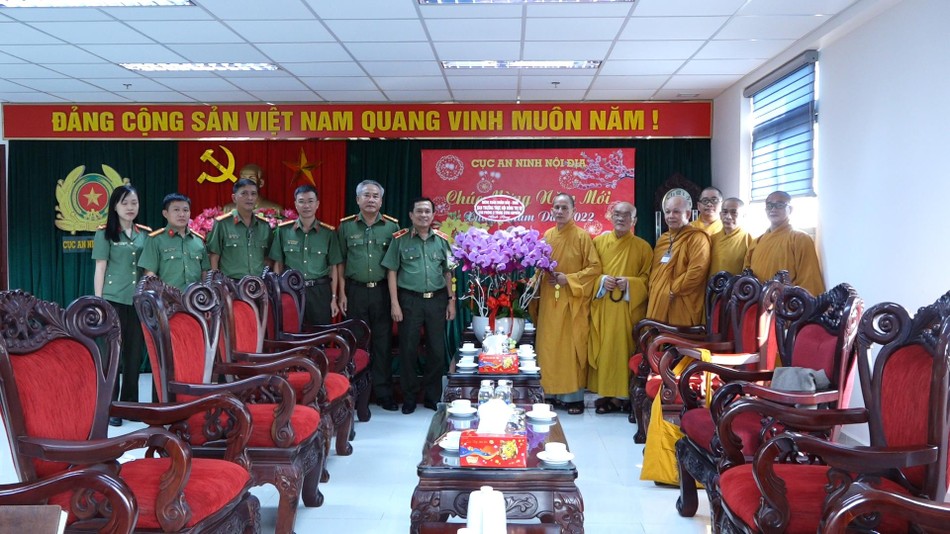 Hòa thượng Thích Thiện Thống thay mặt đoàn chư tôn đức Hội đồng Trị sự tặng hoa chúc Tết đến Thiếu tướng Đoàn Minh Lý