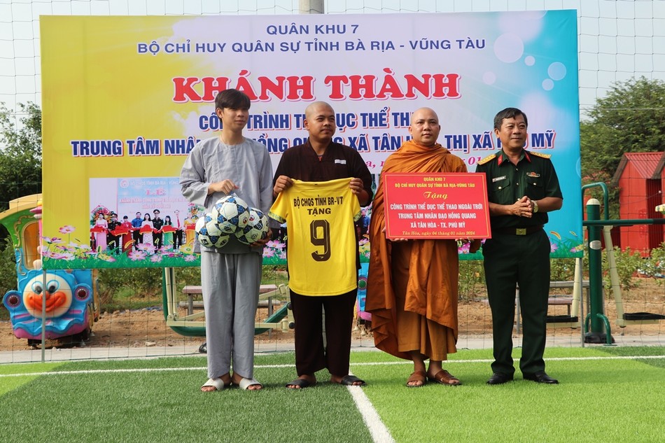 Đại đức Thích Thiện Thông, Giám đốc Trung tâm nhân đạo Hồng Quang nhận bảng trao tặng từ đại diện Bộ Chỉ huy Quân sự tỉnh