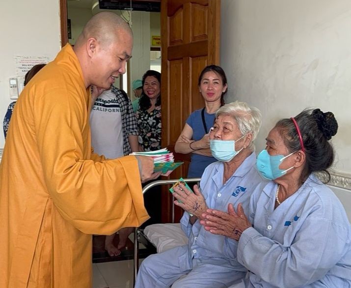 Đại đức Thích Minh Phú trao lộc chúc mừng bệnh nhân sau phẫu thuật - Ảnh: TN
