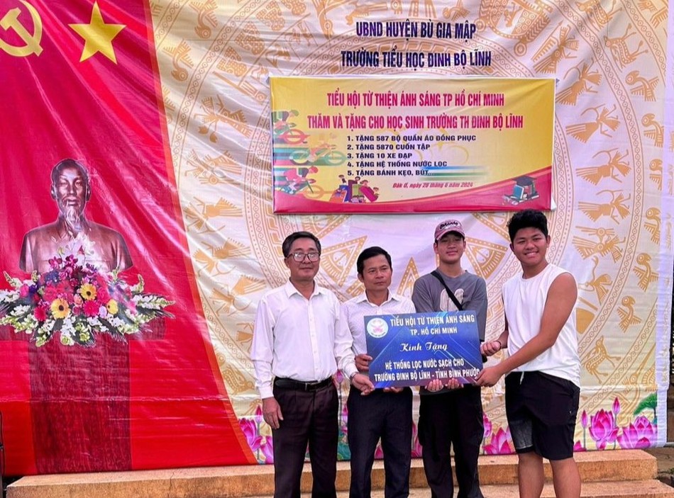 Đại diện đoàn trao bảng tượng trưng hệ thống máy lọc nước