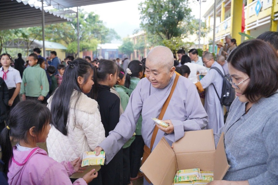 Thành viên đoàn tặng quà bánh cho trẻ em