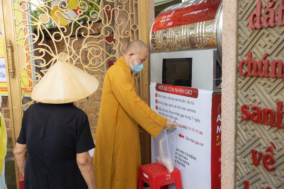 Hòa thượng Thích Minh Thiện, Trưởng Ban Trị sự GHPGVN tỉnh Long An hướng dẫn bà con nhận gạo từ ATM tự động - Ảnh: Phùng Anh Quốc Hòa thượng Thích Minh Thiện, Trưởng Ban Trị sự GHPGVN tỉnh Long An hướng dẫn bà con nhận gạo từ ATM tự động - Ảnh: Phùng Anh Quốc