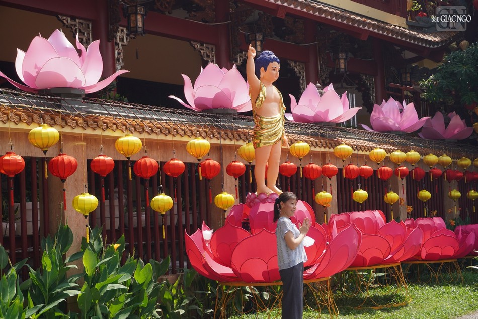 Phật tử chụp hình lưu niệm bên tôn tượng Đức Phật đản sanh