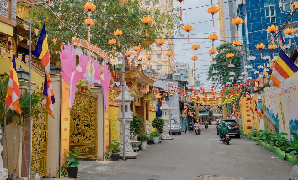 Cờ, hoa kính mừng Phật đản ở hẻm dẫn vào chùa Minh Đạo