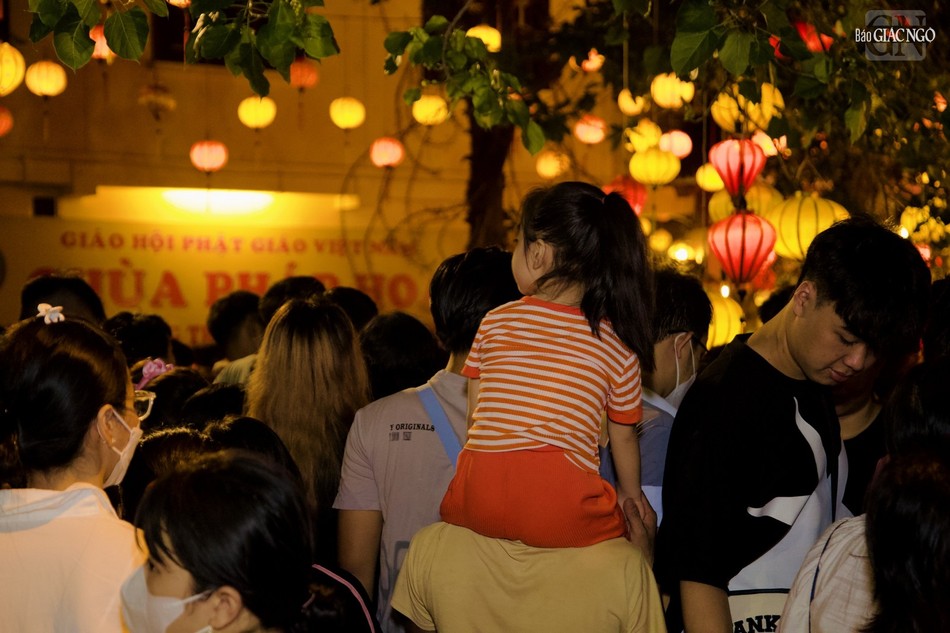 Em bé được cõng trên lưng người thân dự lễ