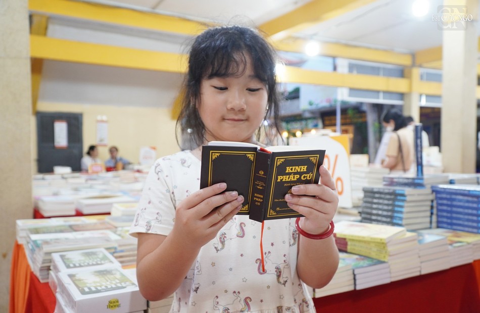 Một em bé chăm chú đọc quyển kinh Pháp cú Một em bé chăm chú đọc quyển kinh Pháp cú