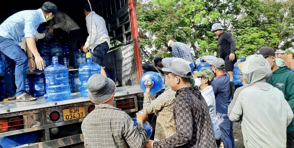 Nước uống đóng bình được chuyển từ trên xe xuống để trao cho bà con vùng hạn mặn Nước uống đóng bình được chuyển từ trên xe xuống để trao cho bà con vùng hạn mặn