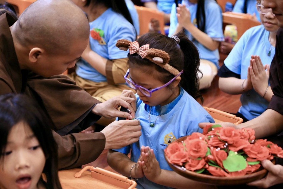 Em trân trọng đón nhận hoa hồng cài trên ngực áo. Đây là khoảnh khắc đẹp với các bạn nhỏ trong khóa tu &quot;Học làm người có ích&quot;