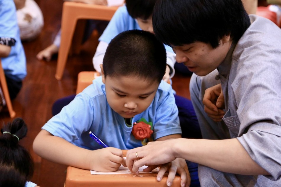 Các bạn thiếu nhi được anh chị tình nguyện viên hướng dẫn viết thư gửi ba mẹ nhân mùa Vu lan - Báo hiếu