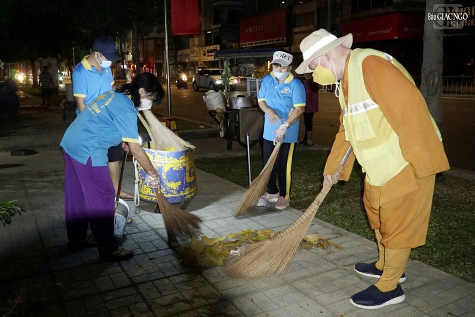 Thành viên đoàn cẩn thận quét sạch vỉa hè, nơi có nhiều lá cây rơi rụng trong đêm
