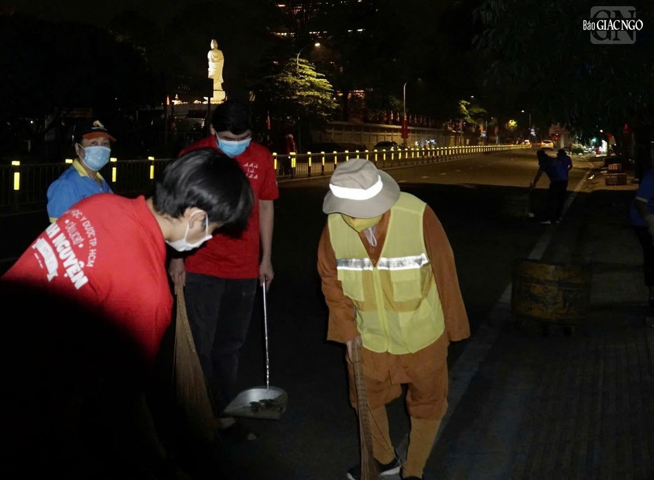 Các bạn sinh viên cùng tham gia vệ sinh khu vực bên ngoài Việt Nam Quốc Tự, trên vỉa hè đường Lê Hồng Phong