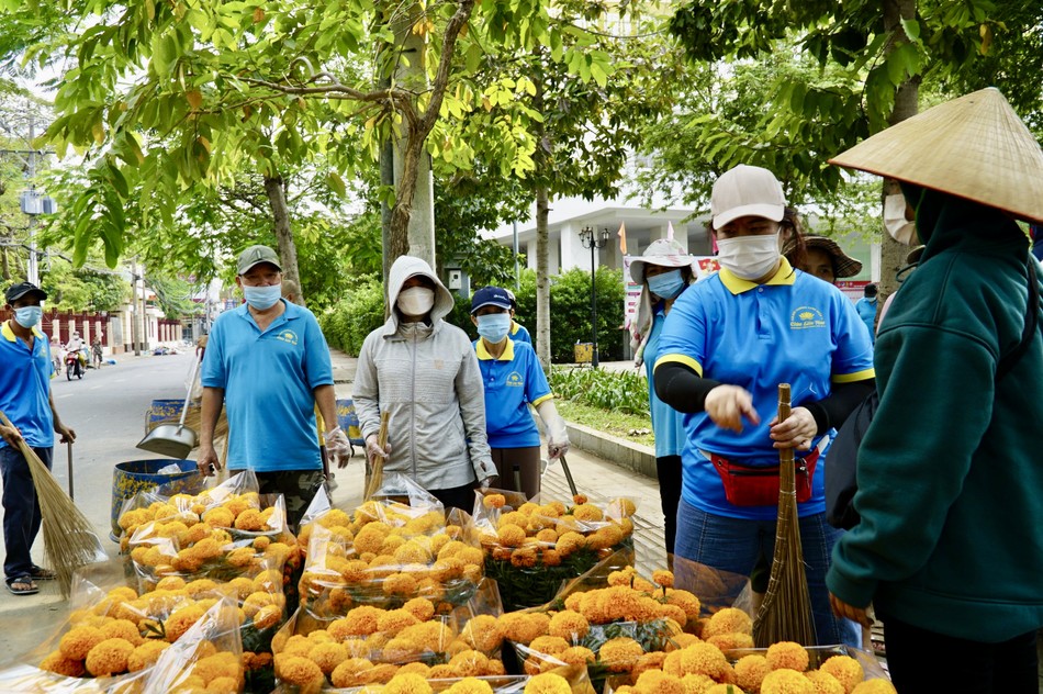 Trong lúc vệ sinh đường phố, thành viên Câu lạc bộ Hành Trình Xanh còn mua hoa giúp các tiểu thương bán hoa ế, giúp phần nào cho bà con có Tết