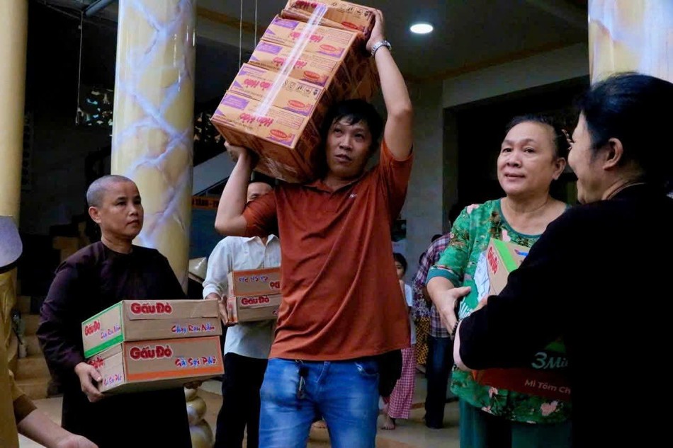 Người ta không chỉ đem quà đến rồi đi, mà còn gửi theo đó niềm mong mỏi được sẻ chia, được xoa dịu những mất mát của đồng bào mình - Ảnh: Huệ Quang