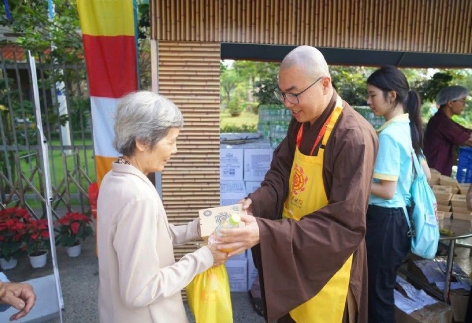 Đại đức Thích Minh Phú trao phần ăn đến Phật tử