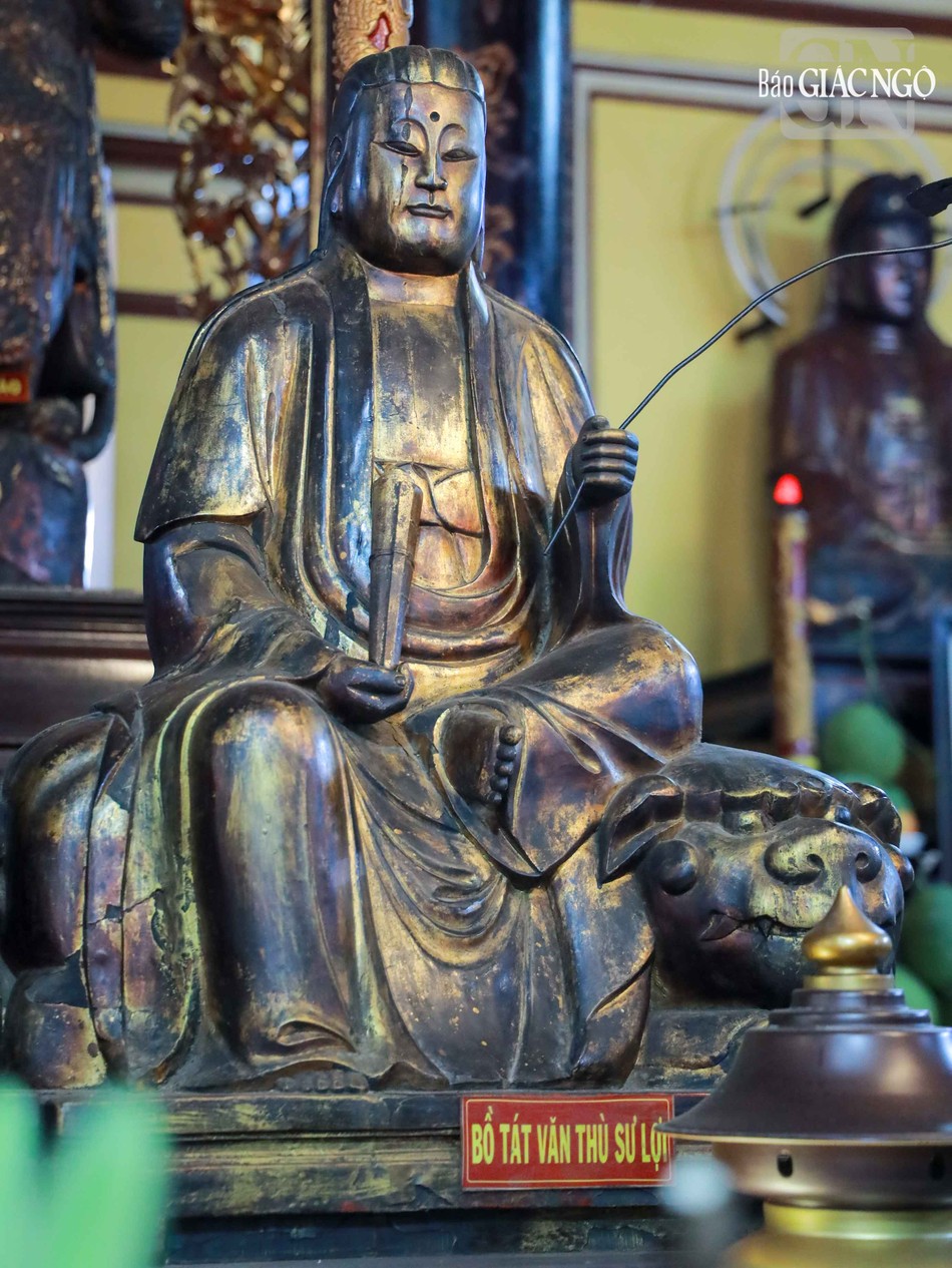 Văn Thù Bồ-tát tay cầm nhành như ý, ngồi trên lưng sư tử