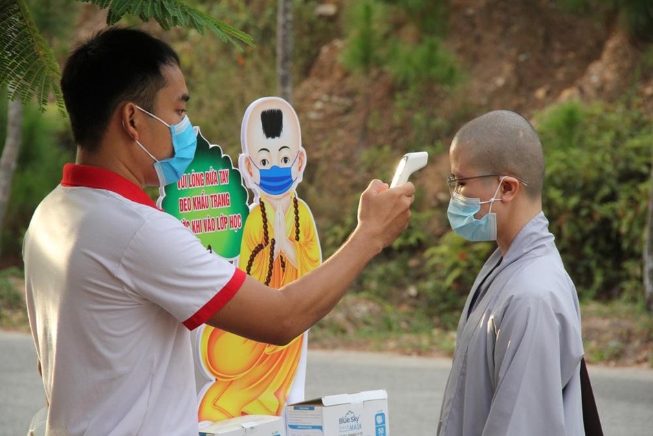 Nhân viên y tế tiến hành đo thân nhiệt trước khi thí sinh vào phòng thi Nhân viên y tế tiến hành đo thân nhiệt trước khi thí sinh vào phòng thi