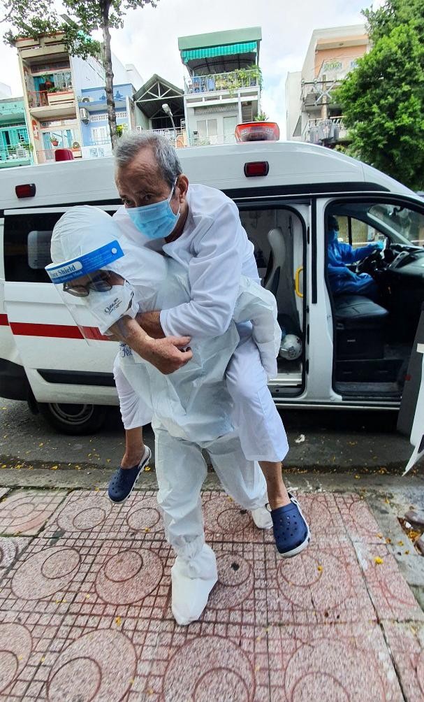 Tình nguyện viên tại Bệnh viện Hồi sức Covid-19 hỗ trợ đưa bệnh nhân về nhà