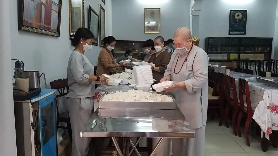 Ni trưởng Thích nữ Từ Nhẫn chuẩn bị những suất cơm chay tặng người nghèo - Ảnh: Như Pháp