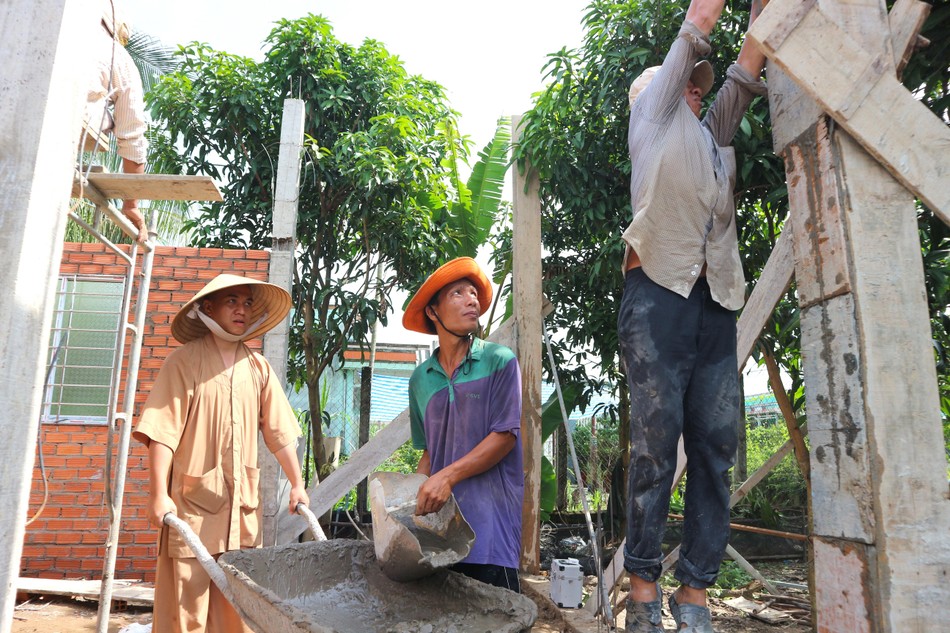 Đại đức Thích Minh Lộc cùng các bạn sinh viên tình nguyện trực tiếp tham gia thi công ngôi nhà mơ ước cho anh Nguyễn Trọng Hiếu