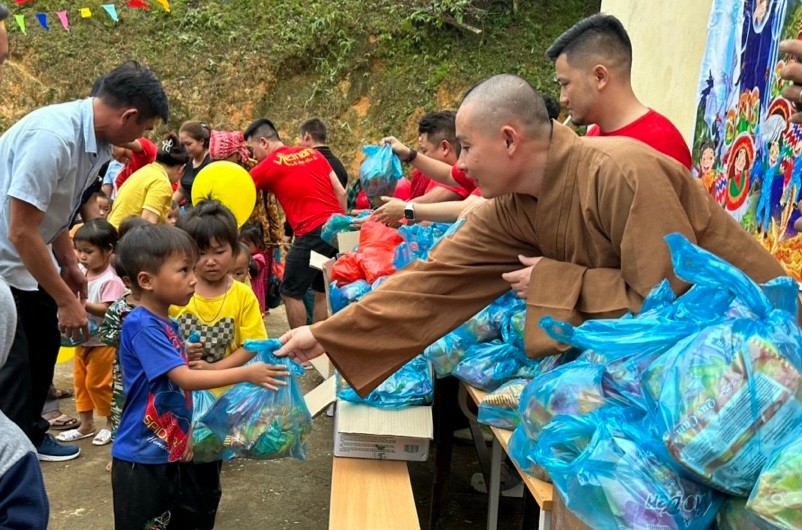 Đại đức Thích Nguyên Sáng trao quà bánh đến các em nhỏ