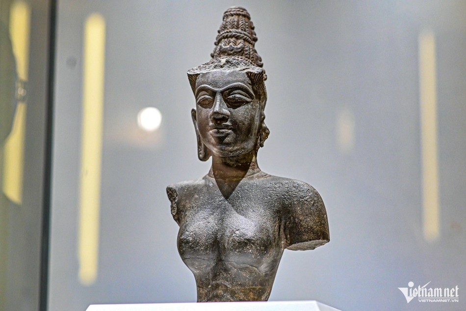 Tượng bán thân nữ thần Devi cao 38,5cm, nặng 20kg, có niên đại thế kỷ X, được phát hiện năm 1911 tại một ngôi đền nhỏ ở Quảng Nam. Tượng bằng đá sa thạch, thể hiện chân dung hiếm gặp của nữ thần Ấn Độ được “Chăm Pa hóa”. Tượng mang những đặc trưng điêu khắc Chăm như lông mày dài, cong và liền nhau, đôi mắt lớn, miệng khẽ cười và búi tóc cao hình tháp. Tác phẩm được công nhận là bảo vật quốc gia năm 2012 Tượng bán thân nữ thần Devi cao 38,5cm, nặng 20kg, có niên đại thế kỷ X, được phát hiện năm 1911 tại một ngôi đền nhỏ ở Quảng Nam. Tượng bằng đá sa thạch, thể hiện chân dung hiếm gặp của nữ thần Ấn Độ được “Chăm Pa hóa”. Tượng mang những đặc trưng điêu khắc Chăm như lông mày dài, cong và liền nhau, đôi mắt lớn, miệng khẽ cười và búi tóc cao hình tháp. Tác phẩm được công nhận là bảo vật quốc gia năm 2012