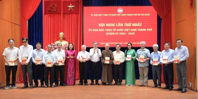 Lãnh đạo Ủy ban MTTQVN TP.HCM tặng sách của cố Tổng Bí thư Nguyễn Phú Trọng đến đại diện 13 tổ chức thành viên - Ảnh: SGGP