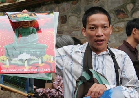 Tượng Phật ngọc tọa lạc trên đài sen trong ngôi chùa cổ miền Bắc. Hai ngày sau khi mở cửa tự do để người dân chiêm bái tượng Phật ngọc, lượng người kéo đến đây vẫn khá đông. Dù lượng người đến xem đông nhưng theo anh thanh niên này, ảnh tượng Phật ngọc bán không đắt hàng. "Xuống giá 10.000 đồng một ảnh to một ảnh nhỏ nhưng cũng chẳng mấy người mua. Từ sáng tới giờ tôi mới bán được chừng 300 tấm", người này nói. Tương tự, các cửa hàng bán tranh tượng Phật in trên gỗ, ảnh tượng Phật in trên đá... cũng ế ẩm. Trong khi đó, một công ty chuyên kinh doanh quà tặng đã chép nguyên mẫu tượng Phật ngọc để đúc lại với kích cỡ nhỏ hơn. Dù không phải làm thủ công mà được đúc bằng bột đá nhưng giá một bức tượng cao chừng 50 cm là 5 triệu đồng, còn bức tượng nhỏ bằng bàn tay giá 300.000 đồng. Loại tượng đặc biệt này đã thu hút sự chú ý của người xem. Tuy nhiên, nhiều người cũng chỉ dám cầm lên xem rồi đặt xuống... ... hay chụp bức ảnh làm kỷ niệm, thay vì chụp bức ảnh Phật ngọc nguyên mẫu được đặt ở quá xa. Dịch vụ chụp ảnh lấy ngay trong 5 phút cũng khá hút khách vì ai cũng muốn có một bức hình làm kỷ niệm nhân dịp tận mắt ngắm bức tượng Phật ngọc lớn nhất thế giới. Còn ở ngoài đường, mỗi khi có ôtô chở khách xịch đỗ là hàng chục người dân đi xe máy chạy tới mời đi xe ôm giá 10.000 - 15.000 đồng một lượt cho quãng đường 5-6 km. Nếu không đi xe ôm, du khách sẽ phải đi bộ vài km mới tới được nơi bày tượng Phật. Tượng Phật ngọc tọa lạc trên đài sen trong ngôi chùa cổ miền Bắc. Hai ngày sau khi mở cửa tự do để người dân chiêm bái tượng Phật ngọc, lượng người kéo đến đây vẫn khá đông. Dù lượng người đến xem đông nhưng theo anh thanh niên này, ảnh tượng Phật ngọc bán không đắt hàng. "Xuống giá 10.000 đồng một ảnh to một ảnh nhỏ nhưng cũng chẳng mấy người mua. Từ sáng tới giờ tôi mới bán được chừng 300 tấm", người này nói. Tương tự, các cửa hàng bán tranh tượng Phật in trên gỗ, ảnh tượng Phật in trên đá... cũng ế ẩm. Trong khi đó, một công ty chuyên kinh doanh quà tặng đã chép nguyên mẫu tượng Phật ngọc để đúc lại với kích cỡ nhỏ hơn. Dù không phải làm thủ công mà được đúc bằng bột đá nhưng giá một bức tượng cao chừng 50 cm là 5 triệu đồng, còn bức tượng nhỏ bằng bàn tay giá 300.000 đồng. Loại tượng đặc biệt này đã thu hút sự chú ý của người xem. Tuy nhiên, nhiều người cũng chỉ dám cầm lên xem rồi đặt xuống... ... hay chụp bức ảnh làm kỷ niệm, thay vì chụp bức ảnh Phật ngọc nguyên mẫu được đặt ở quá xa. Dịch vụ chụp ảnh lấy ngay trong 5 phút cũng khá hút khách vì ai cũng muốn có một bức hình làm kỷ niệm nhân dịp tận mắt ngắm bức tượng Phật ngọc lớn nhất thế giới. Còn ở ngoài đường, mỗi khi có ôtô chở khách xịch đỗ là hàng chục người dân đi xe máy chạy tới mời đi xe ôm giá 10.000 - 15.000 đồng một lượt cho quãng đường 5-6 km. Nếu không đi xe ôm, du khách sẽ phải đi bộ vài km mới tới được nơi bày tượng Phật.