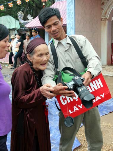 Tượng Phật ngọc tọa lạc trên đài sen trong ngôi chùa cổ miền Bắc. Hai ngày sau khi mở cửa tự do để người dân chiêm bái tượng Phật ngọc, lượng người kéo đến đây vẫn khá đông. Dù lượng người đến xem đông nhưng theo anh thanh niên này, ảnh tượng Phật ngọc bán không đắt hàng. "Xuống giá 10.000 đồng một ảnh to một ảnh nhỏ nhưng cũng chẳng mấy người mua. Từ sáng tới giờ tôi mới bán được chừng 300 tấm", người này nói. Tương tự, các cửa hàng bán tranh tượng Phật in trên gỗ, ảnh tượng Phật in trên đá... cũng ế ẩm. Trong khi đó, một công ty chuyên kinh doanh quà tặng đã chép nguyên mẫu tượng Phật ngọc để đúc lại với kích cỡ nhỏ hơn. Dù không phải làm thủ công mà được đúc bằng bột đá nhưng giá một bức tượng cao chừng 50 cm là 5 triệu đồng, còn bức tượng nhỏ bằng bàn tay giá 300.000 đồng. Loại tượng đặc biệt này đã thu hút sự chú ý của người xem. Tuy nhiên, nhiều người cũng chỉ dám cầm lên xem rồi đặt xuống... ... hay chụp bức ảnh làm kỷ niệm, thay vì chụp bức ảnh Phật ngọc nguyên mẫu được đặt ở quá xa. Dịch vụ chụp ảnh lấy ngay trong 5 phút cũng khá hút khách vì ai cũng muốn có một bức hình làm kỷ niệm nhân dịp tận mắt ngắm bức tượng Phật ngọc lớn nhất thế giới. Còn ở ngoài đường, mỗi khi có ôtô chở khách xịch đỗ là hàng chục người dân đi xe máy chạy tới mời đi xe ôm giá 10.000 - 15.000 đồng một lượt cho quãng đường 5-6 km. Nếu không đi xe ôm, du khách sẽ phải đi bộ vài km mới tới được nơi bày tượng Phật. Tượng Phật ngọc tọa lạc trên đài sen trong ngôi chùa cổ miền Bắc. Hai ngày sau khi mở cửa tự do để người dân chiêm bái tượng Phật ngọc, lượng người kéo đến đây vẫn khá đông. Dù lượng người đến xem đông nhưng theo anh thanh niên này, ảnh tượng Phật ngọc bán không đắt hàng. "Xuống giá 10.000 đồng một ảnh to một ảnh nhỏ nhưng cũng chẳng mấy người mua. Từ sáng tới giờ tôi mới bán được chừng 300 tấm", người này nói. Tương tự, các cửa hàng bán tranh tượng Phật in trên gỗ, ảnh tượng Phật in trên đá... cũng ế ẩm. Trong khi đó, một công ty chuyên kinh doanh quà tặng đã chép nguyên mẫu tượng Phật ngọc để đúc lại với kích cỡ nhỏ hơn. Dù không phải làm thủ công mà được đúc bằng bột đá nhưng giá một bức tượng cao chừng 50 cm là 5 triệu đồng, còn bức tượng nhỏ bằng bàn tay giá 300.000 đồng. Loại tượng đặc biệt này đã thu hút sự chú ý của người xem. Tuy nhiên, nhiều người cũng chỉ dám cầm lên xem rồi đặt xuống... ... hay chụp bức ảnh làm kỷ niệm, thay vì chụp bức ảnh Phật ngọc nguyên mẫu được đặt ở quá xa. Dịch vụ chụp ảnh lấy ngay trong 5 phút cũng khá hút khách vì ai cũng muốn có một bức hình làm kỷ niệm nhân dịp tận mắt ngắm bức tượng Phật ngọc lớn nhất thế giới. Còn ở ngoài đường, mỗi khi có ôtô chở khách xịch đỗ là hàng chục người dân đi xe máy chạy tới mời đi xe ôm giá 10.000 - 15.000 đồng một lượt cho quãng đường 5-6 km. Nếu không đi xe ôm, du khách sẽ phải đi bộ vài km mới tới được nơi bày tượng Phật.