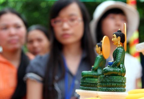 Tượng Phật ngọc tọa lạc trên đài sen trong ngôi chùa cổ miền Bắc. Hai ngày sau khi mở cửa tự do để người dân chiêm bái tượng Phật ngọc, lượng người kéo đến đây vẫn khá đông. Dù lượng người đến xem đông nhưng theo anh thanh niên này, ảnh tượng Phật ngọc bán không đắt hàng. "Xuống giá 10.000 đồng một ảnh to một ảnh nhỏ nhưng cũng chẳng mấy người mua. Từ sáng tới giờ tôi mới bán được chừng 300 tấm", người này nói. Tương tự, các cửa hàng bán tranh tượng Phật in trên gỗ, ảnh tượng Phật in trên đá... cũng ế ẩm. Trong khi đó, một công ty chuyên kinh doanh quà tặng đã chép nguyên mẫu tượng Phật ngọc để đúc lại với kích cỡ nhỏ hơn. Dù không phải làm thủ công mà được đúc bằng bột đá nhưng giá một bức tượng cao chừng 50 cm là 5 triệu đồng, còn bức tượng nhỏ bằng bàn tay giá 300.000 đồng. Loại tượng đặc biệt này đã thu hút sự chú ý của người xem. Tuy nhiên, nhiều người cũng chỉ dám cầm lên xem rồi đặt xuống... ... hay chụp bức ảnh làm kỷ niệm, thay vì chụp bức ảnh Phật ngọc nguyên mẫu được đặt ở quá xa. Dịch vụ chụp ảnh lấy ngay trong 5 phút cũng khá hút khách vì ai cũng muốn có một bức hình làm kỷ niệm nhân dịp tận mắt ngắm bức tượng Phật ngọc lớn nhất thế giới. Còn ở ngoài đường, mỗi khi có ôtô chở khách xịch đỗ là hàng chục người dân đi xe máy chạy tới mời đi xe ôm giá 10.000 - 15.000 đồng một lượt cho quãng đường 5-6 km. Nếu không đi xe ôm, du khách sẽ phải đi bộ vài km mới tới được nơi bày tượng Phật. Tượng Phật ngọc tọa lạc trên đài sen trong ngôi chùa cổ miền Bắc. Hai ngày sau khi mở cửa tự do để người dân chiêm bái tượng Phật ngọc, lượng người kéo đến đây vẫn khá đông. Dù lượng người đến xem đông nhưng theo anh thanh niên này, ảnh tượng Phật ngọc bán không đắt hàng. "Xuống giá 10.000 đồng một ảnh to một ảnh nhỏ nhưng cũng chẳng mấy người mua. Từ sáng tới giờ tôi mới bán được chừng 300 tấm", người này nói. Tương tự, các cửa hàng bán tranh tượng Phật in trên gỗ, ảnh tượng Phật in trên đá... cũng ế ẩm. Trong khi đó, một công ty chuyên kinh doanh quà tặng đã chép nguyên mẫu tượng Phật ngọc để đúc lại với kích cỡ nhỏ hơn. Dù không phải làm thủ công mà được đúc bằng bột đá nhưng giá một bức tượng cao chừng 50 cm là 5 triệu đồng, còn bức tượng nhỏ bằng bàn tay giá 300.000 đồng. Loại tượng đặc biệt này đã thu hút sự chú ý của người xem. Tuy nhiên, nhiều người cũng chỉ dám cầm lên xem rồi đặt xuống... ... hay chụp bức ảnh làm kỷ niệm, thay vì chụp bức ảnh Phật ngọc nguyên mẫu được đặt ở quá xa. Dịch vụ chụp ảnh lấy ngay trong 5 phút cũng khá hút khách vì ai cũng muốn có một bức hình làm kỷ niệm nhân dịp tận mắt ngắm bức tượng Phật ngọc lớn nhất thế giới. Còn ở ngoài đường, mỗi khi có ôtô chở khách xịch đỗ là hàng chục người dân đi xe máy chạy tới mời đi xe ôm giá 10.000 - 15.000 đồng một lượt cho quãng đường 5-6 km. Nếu không đi xe ôm, du khách sẽ phải đi bộ vài km mới tới được nơi bày tượng Phật.