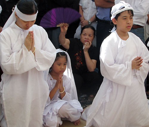 Vợ con đạo diễn Huỳnh Phúc Điền quỳ trước huyệt mộ anh.