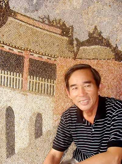 Ông Năm bên bức tranh "Chùa Cầu Hội An" làm từ ốc ruốc. Ảnh: Thế Lực.