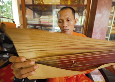 Lá Sách tra được phơi khô, cắt thành mảnh ngang 6 cm, dài 60 cm, được khắc chữ rồi dùng mực mài lên mà thành kinh Phật. Ảnh: Gia Bảo Lá Sách tra được phơi khô, cắt thành mảnh ngang 6 cm, dài 60 cm, được khắc chữ rồi dùng mực mài lên mà thành kinh Phật. Ảnh: Gia Bảo