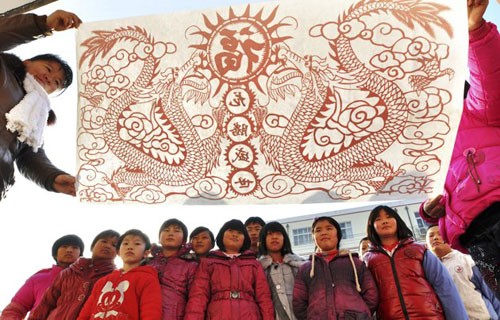 Các công nhân đang lắp đặt đèn lồng khổng lồ hình con rồng trên một hồ nước để chào đón năm mới Âm lịch ở Suining, tỉnh Tứ Xuyên. Năm mới cổ truyền ở Trung Quốc sẽ bắt đầu từ ngày 23/1 Dương lịch. Những người đàn ông Trung Quốc múa rồng trên một hồ nước đóng băng chào đón năm mới ở Shenyang, tỉnh Liêu Ninh ngày 1/1/2012. Thợ lặn múa rồng trong một sự kiện chào đón năm mới Âm lịch ở trong một bể cá tại Bắc Kinh ngày 5/1/2012. Công nhân trang trí một bức tượng hình con rồng để chuẩn bị cho một sự kiện chào đón năm mới cổ truyền ở Ôn Châu, Chiết Giang ngày 9/1. Một công nhân xịt sơn cho bộ phận của chiếc đèn lồng hình người, để chuẩn bị cho một sự kiện chào đón năm mới ở Suining, Tứ Xuyên. Công nhân đang lắp đặt một đèn lồng hình rồng ở trên tường ở Nam Kinh. Du khách chụp hình chiếc đèn lồng hình rồng rực sáng trong đêm ở Bắc Kinh ngày 7/1. Người mẫu đội một chiếc mũ làm từ chocolate, tại sự kiện Chocolate Thế giới ở Thượng Hải để chào đón năm mới. Học sinh cầm câu đối, đèn lồng và múa rồng để chào đóng năm mới tại một ngôi trường tiểu học tại Cửu Giang, Giang Tây. Công nhân nhập cư dùng bữa tại một công trường ở Thành Đô, Trung Quốc ngày 9/1. Hơn 1.400 công nhân nhập cư đã tham gia bữa ăn thường niên để chào mừng năm mới. Đèn lồng trang hoàng rực rỡ tại một con phố ở Zibo, Trung Quốc ngày 8/1. Công nhân đang dựng một bức tượng hình Quan Âm trên những chiếc đèn lồng hình rồng ở Tứ Xuyên ngày 7/1. Một giáo viên đang cho các học sinh xem bức tranh hình rồng ở một ngôi trường tiểu học tại tỉnh Sơn Đông ngày 5/1. Người đàn ông giơ bức thư có gắn tem hình rồng tại Huaibei, tỉnh An Huy ngày 5/1. Tem thư được thiết kế có hình rồng này đã gây ra sự chỉ trích của người dân, khi họ cho rằng con rồng này có hình dáng quá hung tợn.