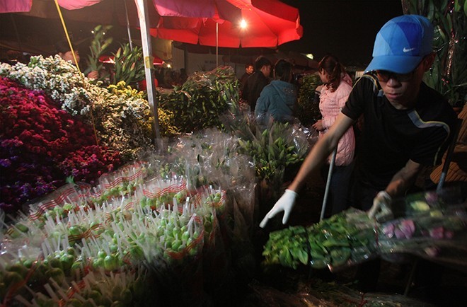 Cái rét đêm của mùa đông Hà Nội kèm chút sương muối không làm ảnh hưởng nhiều đến công việc của người bán hoa.