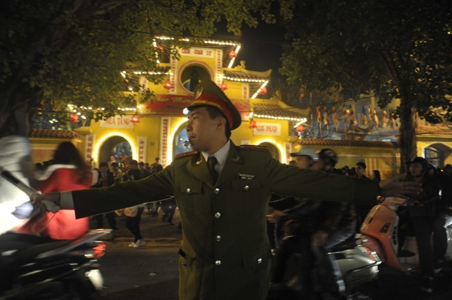 Anh Trần Thanh Tùng, công an phường Quán Sứ vất vả phân luồng trước cửa chùa.