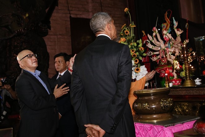 Giáo sư Dương Ngọc Dũng giải thích cho TT Obama về ý nghĩa của việc thắp ba cây nhang. Ảnh: Hải An. Nguoi huong dan ong Obama o chua Ngoc Hoang ke gi? hinh anh 1